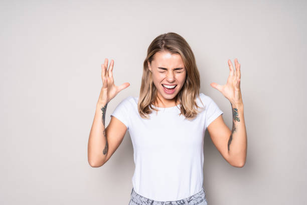 istock Young angry pretty woman screaming isolated on white background 1286958323