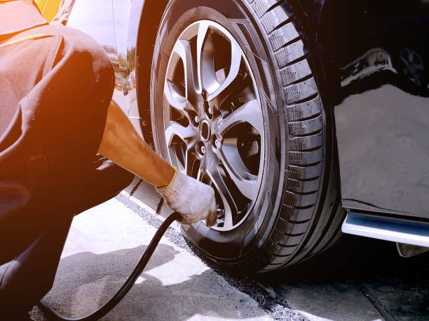 le mécanicien remplit les pneus de voiture au garage. le technicien vérifie l’état des pneus pour prévenir les accidents. - air needle photos et images de collection