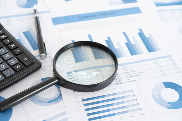 investment business report business and investment planning. Magnifying glass with business report on financial advisor desk. Concept of data analysis, accounting,audit, business research. shareholder stock pictures, royalty-free photos & images