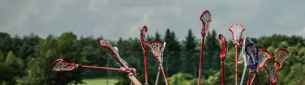 raised lacrosse sticks against the sky