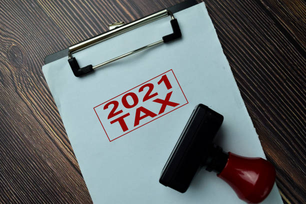 istock Red Handle Rubber Stamper and 2021 Tax text isolated on the table. 1286975142
