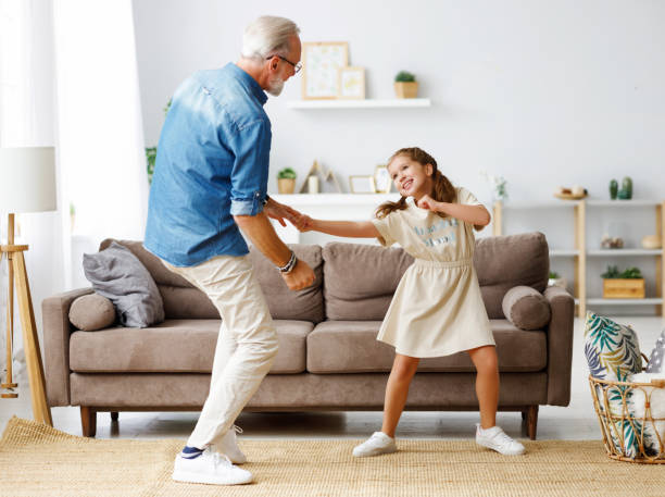istock Grandfather dancing with granddaughter at home 1286982554