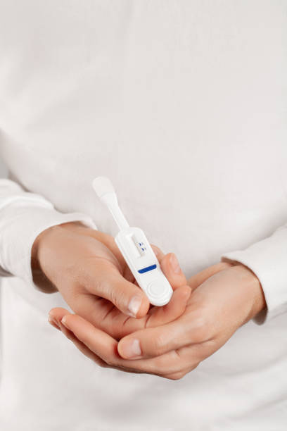 istock Man holding oral HIV test on white background. 1286986722