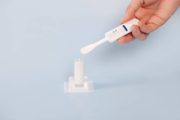 istock Man holding oral HIV test on blue background. 1286986726