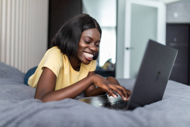 istock Woman lying on her belly using a laptop in her bedroom. Working from home in quarantine lockdown. Social distancing. Self Isolation 1286987591