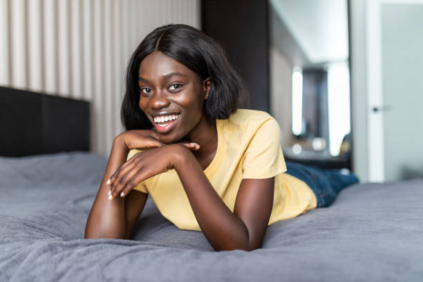 istock Smiling african woman lying in her bedroom 1286989621