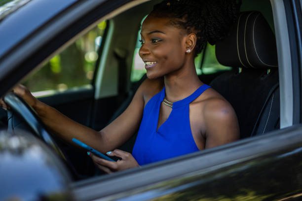 istock African young woman using mobile phone while driving car 1286992983