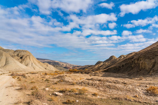 istock Blue sky with clouds and rocks in the high mountain desert 1286993722