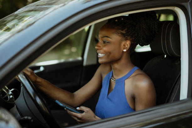 istock African young woman using mobile phone while driving car 1286994144