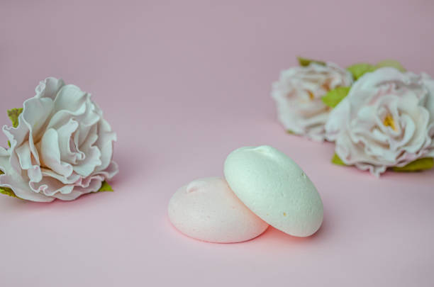 istock Meringues and a flower on a pink background. 1286994259