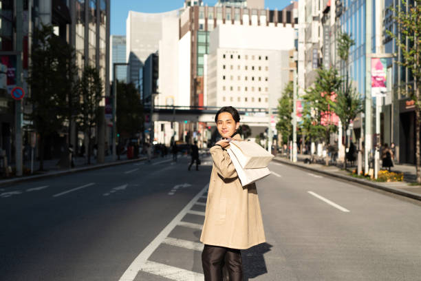 istock Man with shopping bag looking over shoulder on street 1286998071