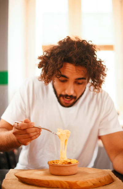istock Young Man Eating Mac and Cheese 1286999257