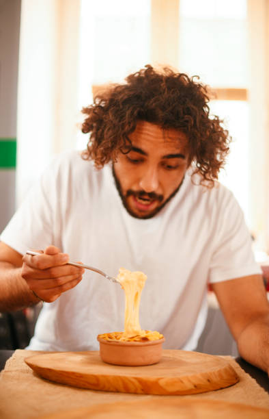 istock Young Man Eating Mac and Cheese 1286999585