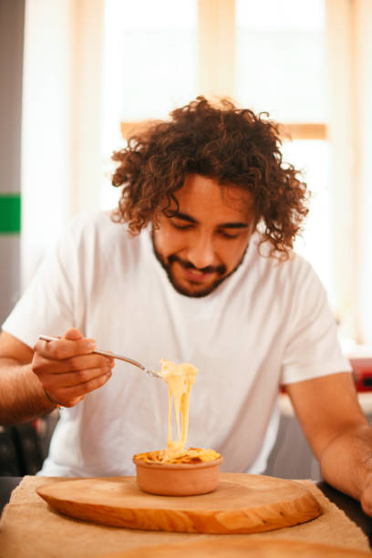 istock Young Man Eating Mac and Cheese 1286999589