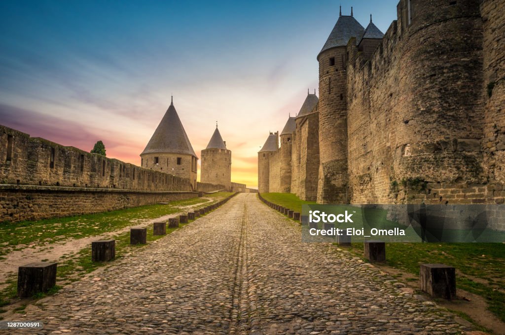 walls of Carcassonne at sunrise Walls and towers of medieval city of Carcassonne at sunset, France Carcassonne Stock Photo