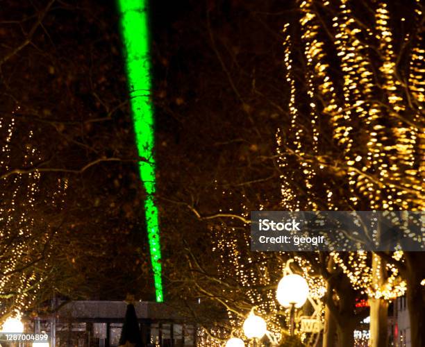 Laser Beam Over 15 Km Through The City Center Sign Of Optimism In Corona Lockdown With Winterly Decorated Trees At The Edge Of The Pedestrian Zone Stock Photo - Download Image Now