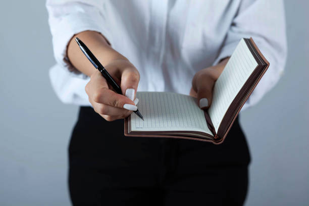 istock woman hand pen and notepad 1287008309