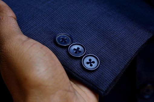 blue black blazer sleeves button closeup texture hand holding