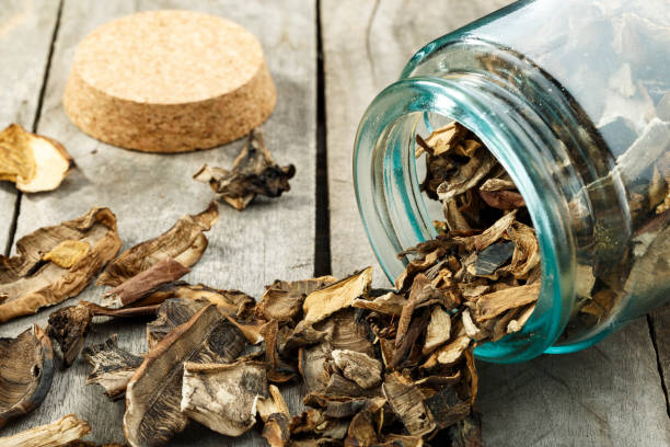 istock Dried mushrooms in a glass jar on a wooden table. Space for text. 1287008545