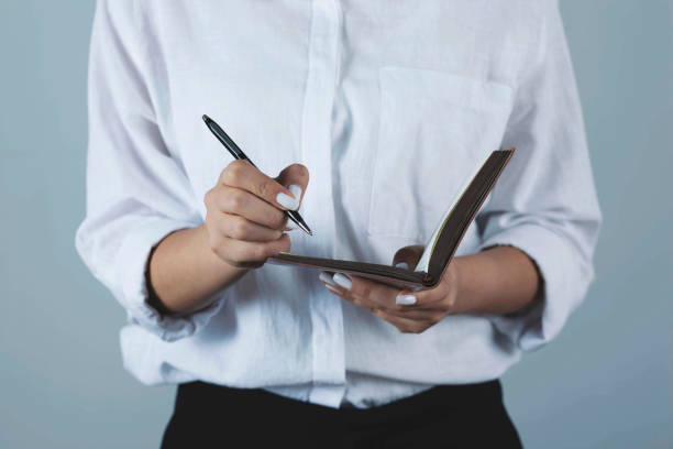 istock woman hand pen and notepad 1287009743