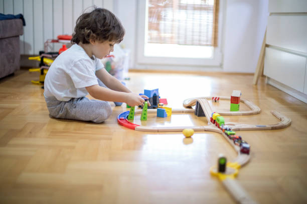 istock Beautiful little boy playing with a railroad train toy. 1287016203