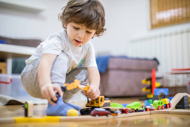 istock Beautiful little boy playing with a railroad train toy. 1287016207