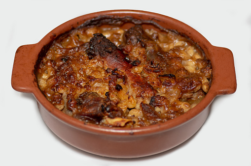 specialty: cassoulet, a meal with white beans, duck leg, sausage and bacon in a white background