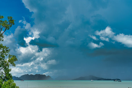 Tropical monsoon storm torrential rain is engulfing the distant islands on the horizon.  Rainy season in Ko Lanta, Thailand, Asia.