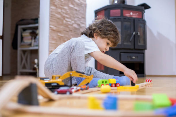 istock Beautiful little boy playing with a railroad train toy. 1287016355
