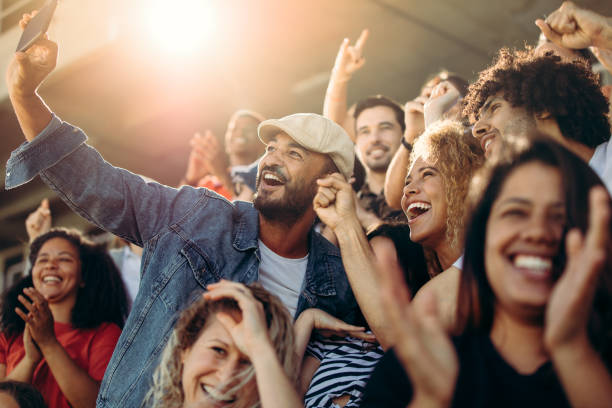 group of supporters taking selfie watching a football match - sports event imagens e fotografias de stock