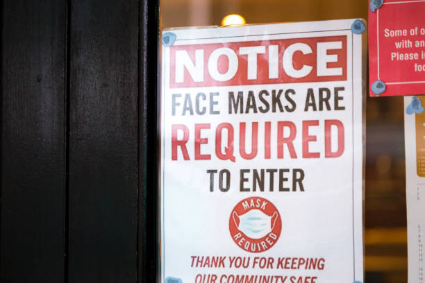 istock Please wear a face mask sign in shop window 1287023054