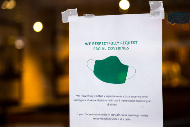istock Please wear a face mask sign in shop window 1287023113