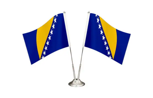 Bosnia and Herzegovina table flag isolated on white ground. Two flag poles with flags and Bosnia and Herzegovina flag on the table.