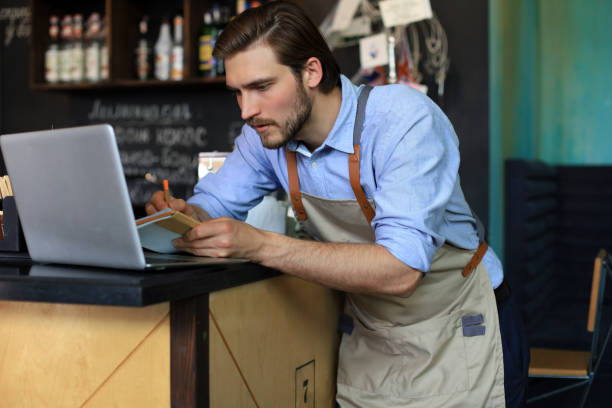 istock Restaurant manager working on laptop, counting profit. 1287024343