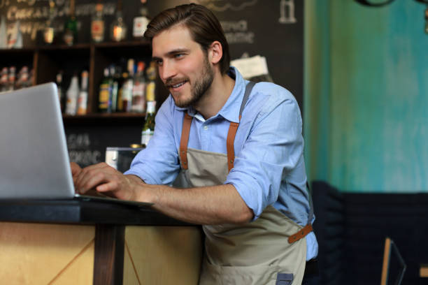 istock Restaurant manager working on laptop, counting profit. 1287024358
