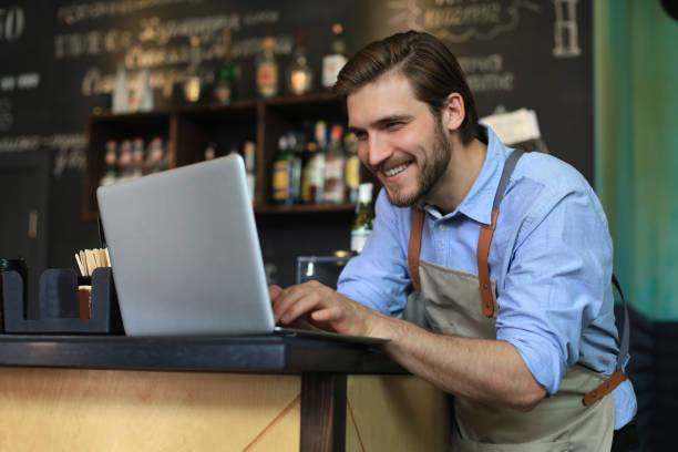 istock Restaurant manager working on laptop, counting profit. 1287024371