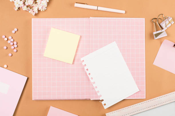 istock flat lay pink stationery on work desk in brown pastel background 1287025751