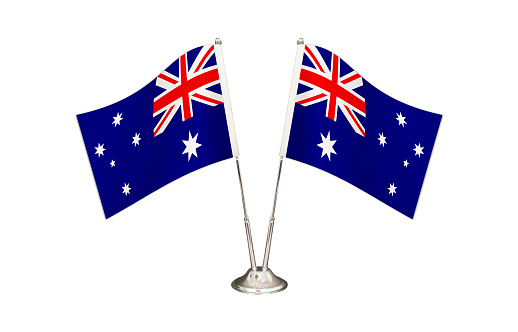 Australia table flag isolated on white ground. Two flag poles with flags and Australia flag on the table.