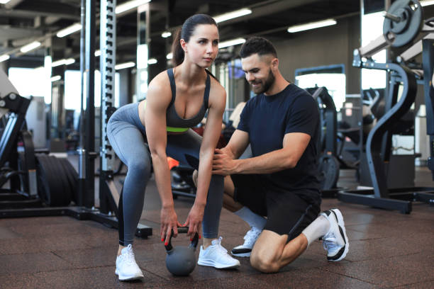 istock Fitness instructor exercising with his client at the gym. 1287027162