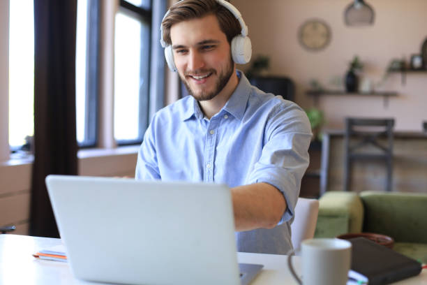 istock Confident man wearing headset speaking and watching business webinar training, listening to lecture. 1287027303