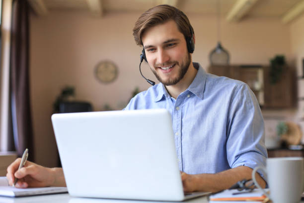 istock Freelance operator talking with headsets and consulting clients from home office. 1287028068