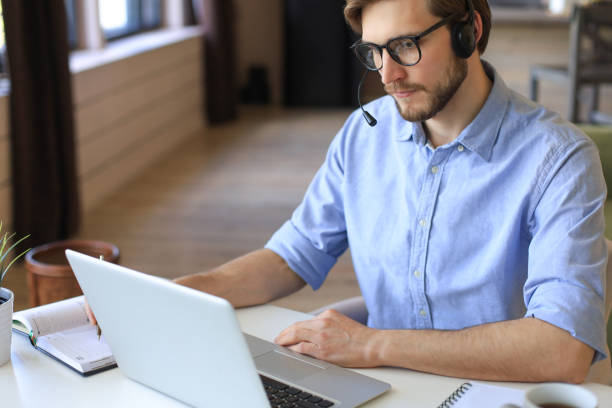 istock Freelance operator talking with headsets and consulting clients from home office. 1287028080