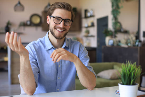 istock Confident happy businessman in eyeglasses sitting at home workplace and looking at camera. 1287028131