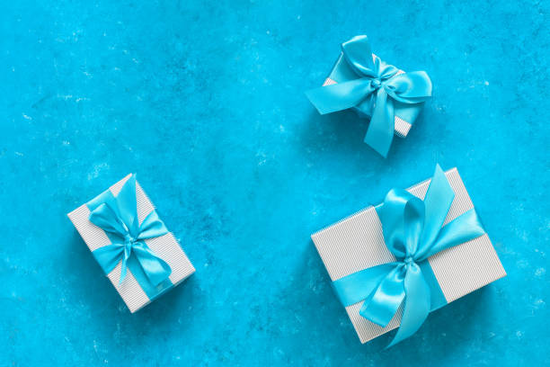 istock Gift boxes with blue ribbon. Turquoise blue grunge background. Top view, flat lay, copy space. 1287028159