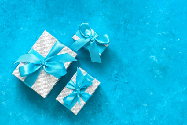 istock Gift boxes with blue ribbon. Blue rustic background. Top view, flat lay, copy space. 1287028169