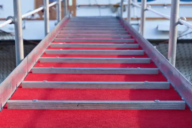 Ships gangway with a red velvet carpet.
