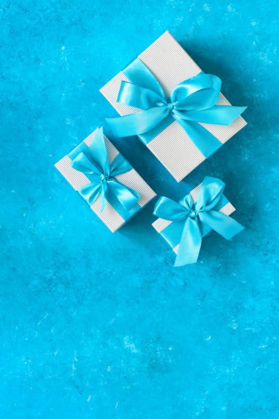 istock Gift boxes with blue ribbon. Turquoise blue grunge background. Top view, flat lay, copy space. 1287028176