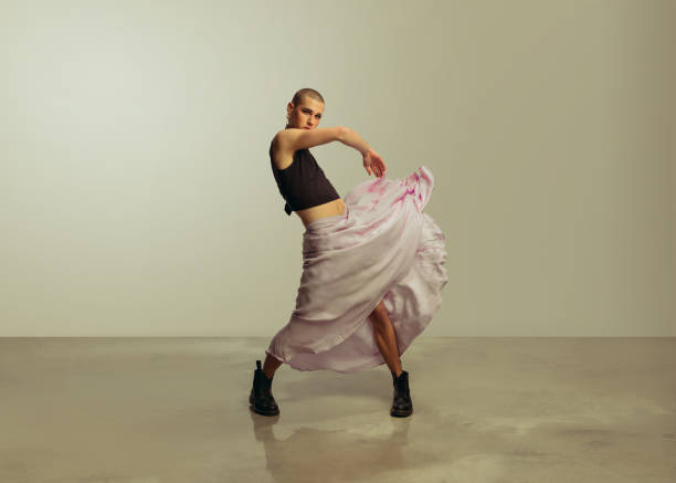 Gay man dancing wearing women clothing Full length of gay man wearing women clothing dancing. Androgynous male wearing crop top and skirt. androgyn stock pictures, royalty-free photos & images