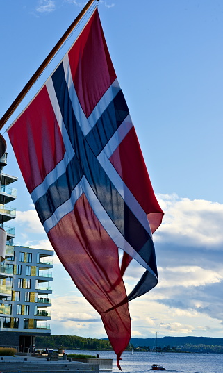 Bandera nacional oficial noruega ondeando en el viento con cielos azules en el fondo. photo