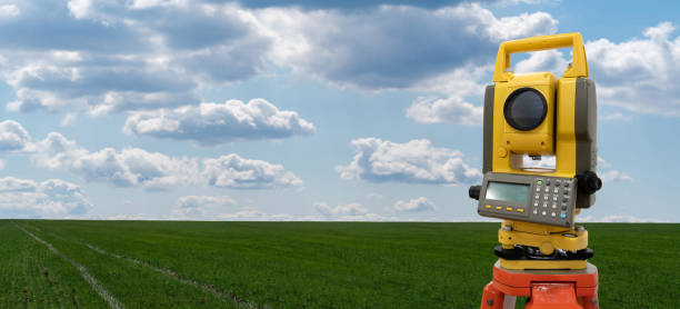 istock Theodolite (total positioning station) on a background of green field 1287029133